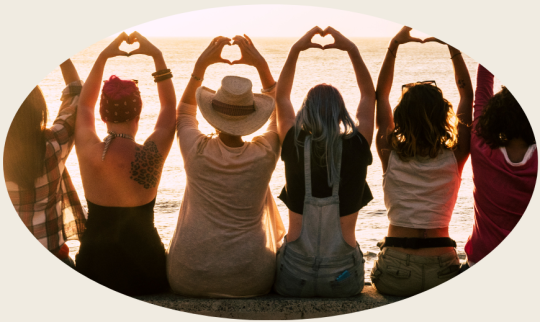 Bild zu Interaktionelle Gruppentherapie für Frauen. Sechs Frauen sitzen nebeneinander. und haben ihre Hände über ihr Köpfe, dabei formen sie ihre Finger zur Herzform. Sie sind von hinten zu sehen.